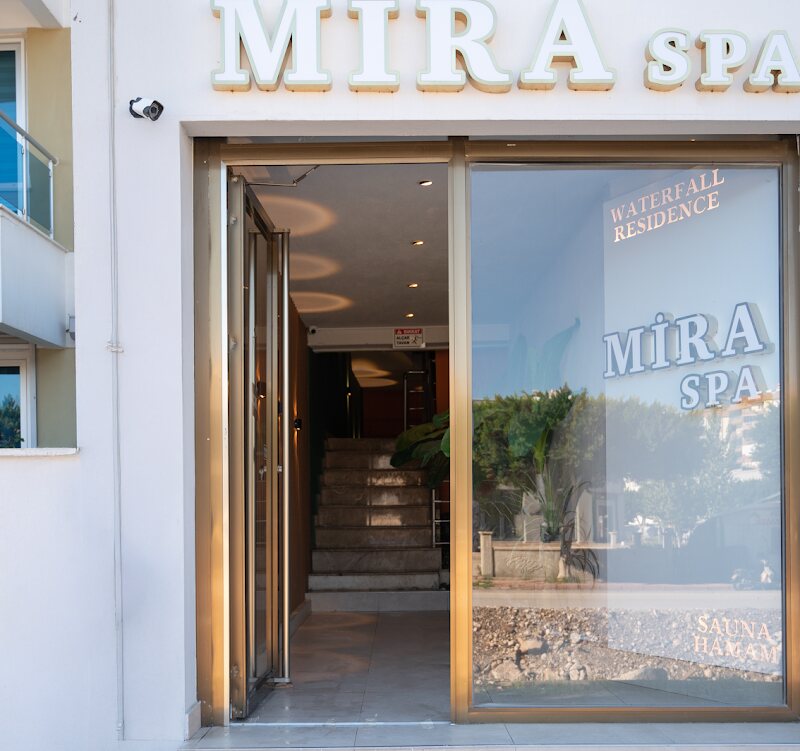 The Mira Spa entrance on the ground floor of Waterfall Residence, with stairs leading down to the spa.