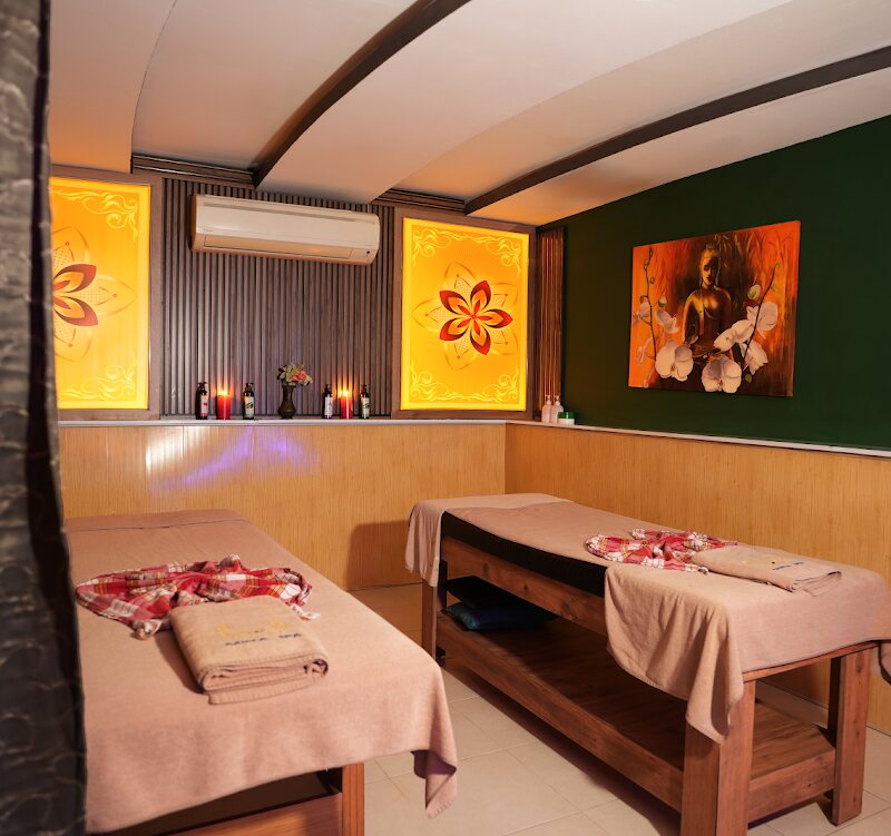 The double treatment room seen from the doorway, towels folded on both beds.