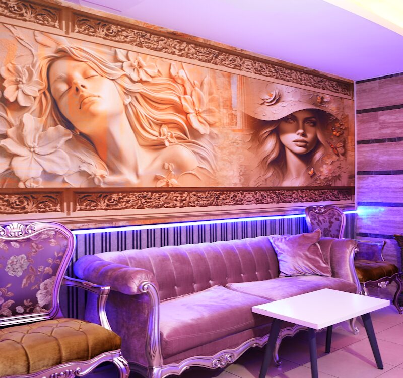 Lounge with a carved relief wall, a velvet sofa and low coloured lighting.